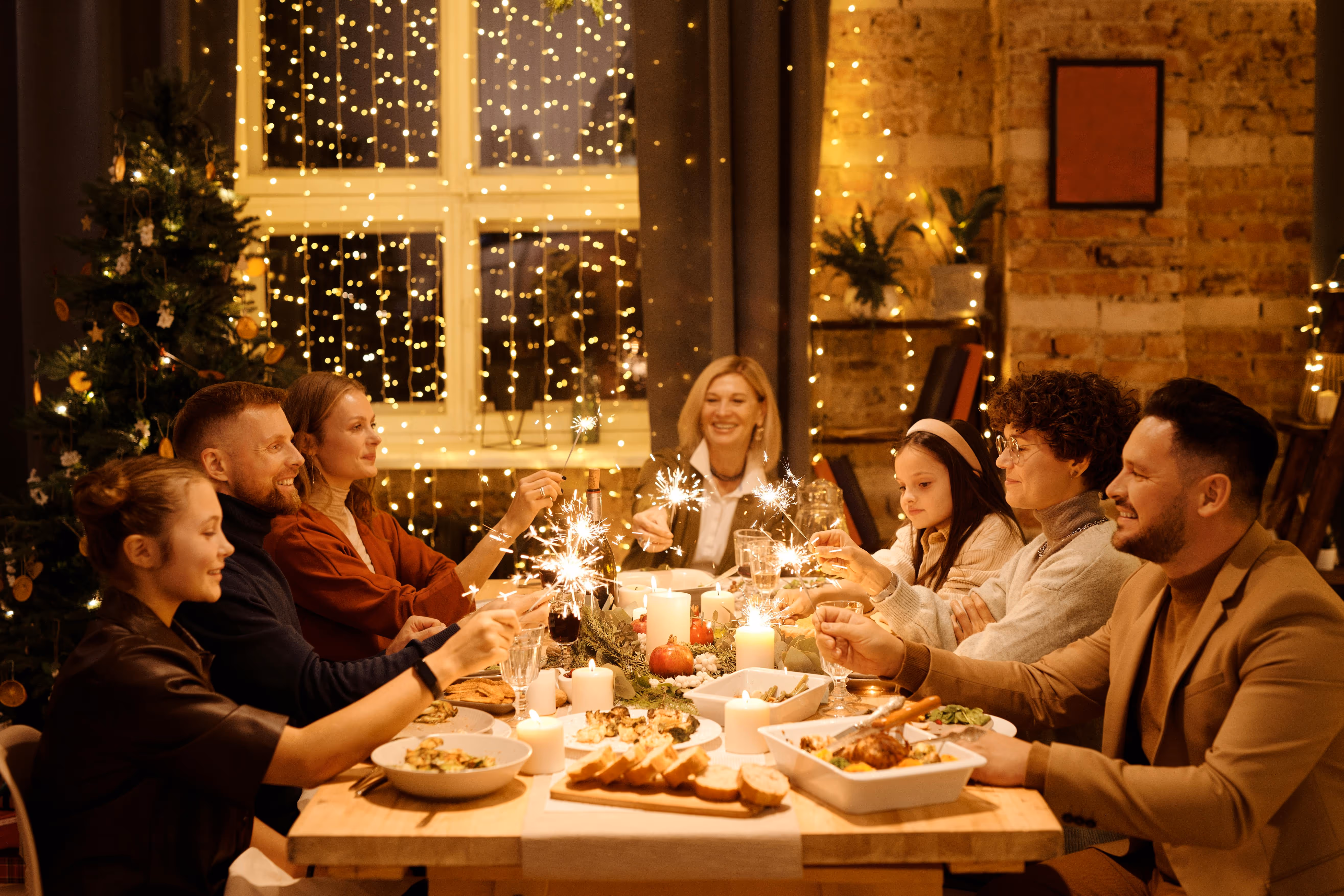 Family celebrating together at dinner with sparklers
